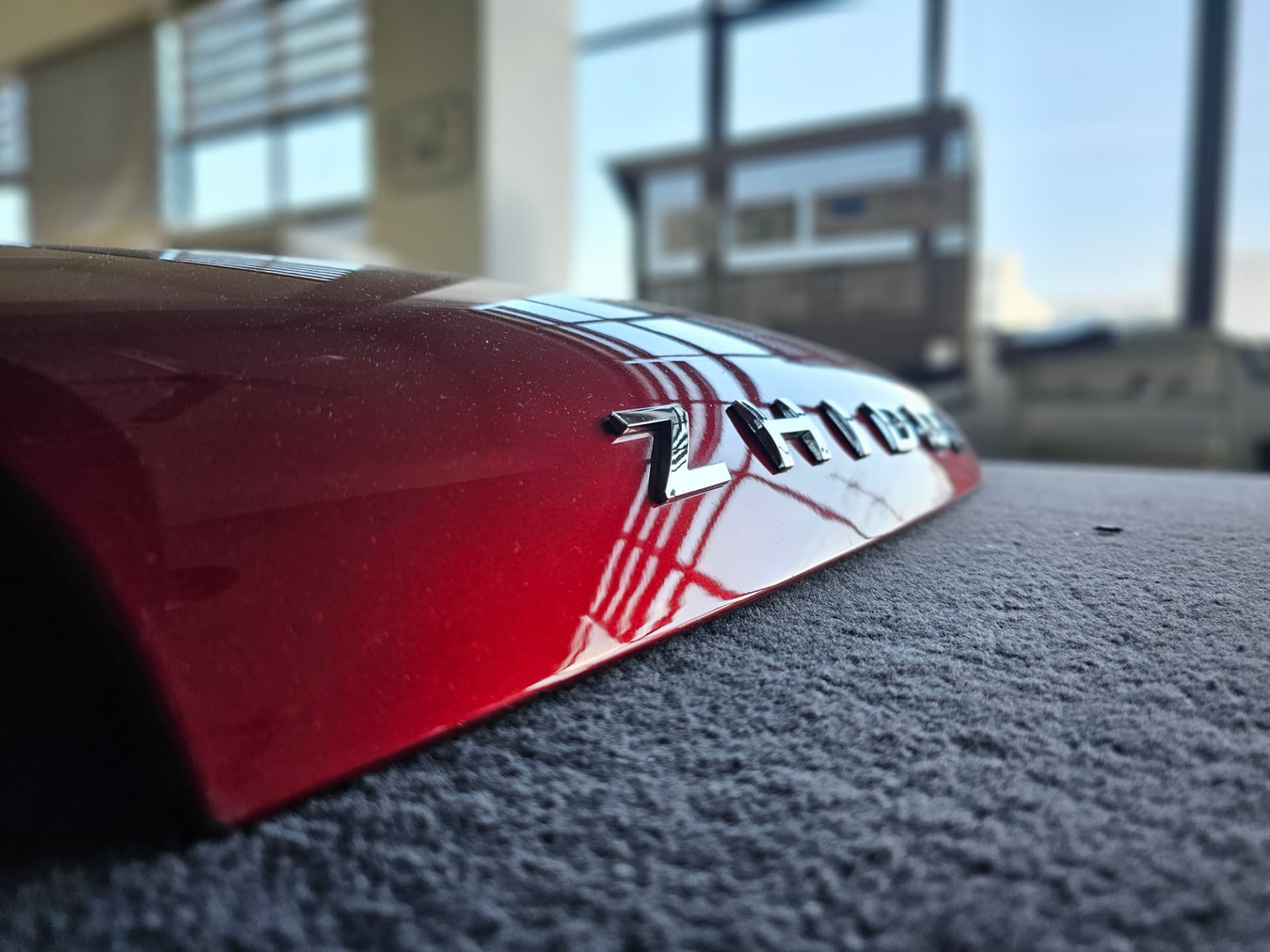 High-gloss candy red painted exterior panel with chrome badge lettering
